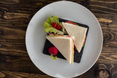 Peynirli lezzetli sandviç ve ahşap arka planda böğürtlen