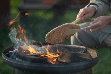 Ortaçağ festivali sırasında insanların ızgarada ekmek pişirirken yakın plan çekimleri.