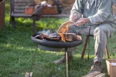 Ortaçağ festivali sırasında insanların ızgarada ekmek pişirirken yakın plan çekimleri.