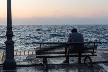 Adam bankta yalnız oturuyor.