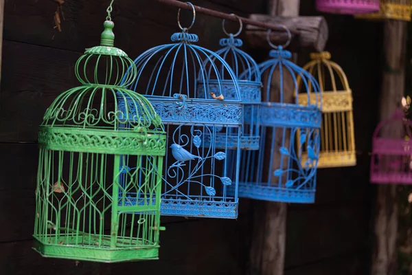 close-up shot of colorful bird cages hanging on street