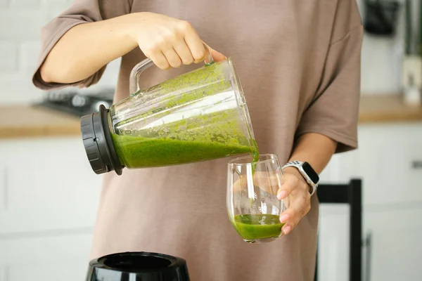 女性的手把绿色的冰沙倒在玻璃杯中 健康的食物 健康的生活方式 节食减肥概念 — 图库照片
