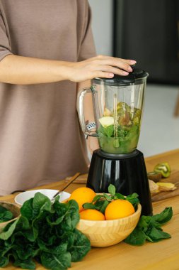 Mutfaktaki yeşil taze içecekten kahvaltı hazırlayan kadın, yakın çekim. Mutfakta doğal detoks limonata hazırlıyorum. Kilo kaybı diyet kavramı