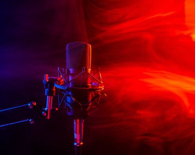 Siyah arka planda kırmızı dumanlı profesyonel mikrofon..