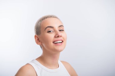 Beyaz arka planda kısa saçlı beyaz bir kadın..