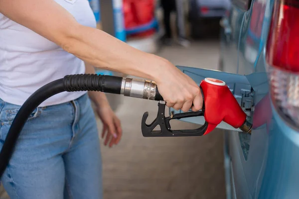 Kobieta tankująca samochód benzyną na stacji benzynowej. — Zdjęcie stockowe