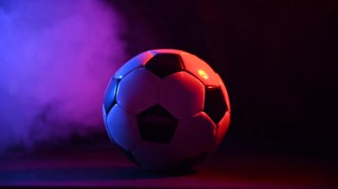 Siyah arka planda mavi pembe dumanlı futbol topu.