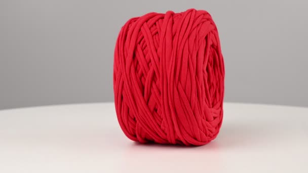 Boule rouge de fil de coton filant sur fond blanc. — Video