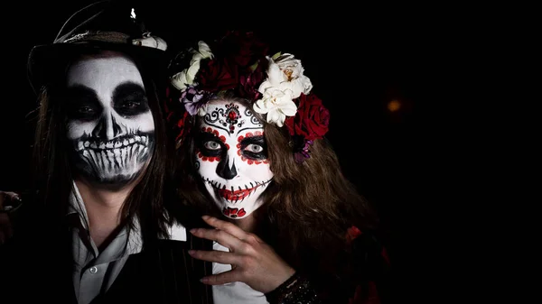 Woman in santa muerte costume and man in skeleton bodypainting for halloween. — Stock Photo, Image
