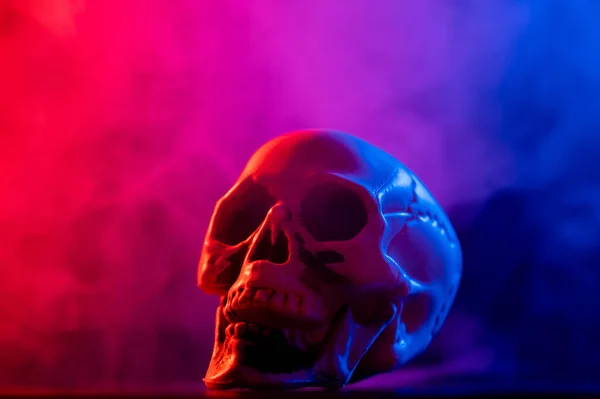 Teschio umano in fumo rosa e blu su fondo nero. Halloween. — Foto Stock