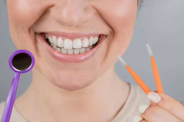Retrato de close-up de uma mulher sorridente segurando uma escova e um espelho dental. Widescreen — Fotografia de Stock