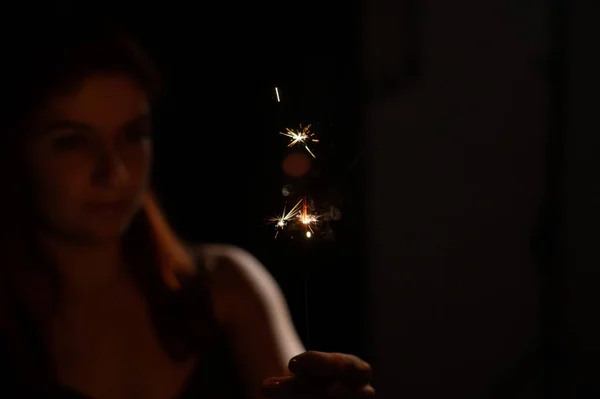 Mulher caucasiana segurando sparkler no escuro. — Fotografia de Stock