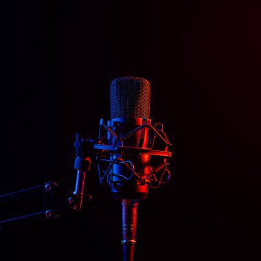 Siyah arka planda pembe dumanlı profesyonel mikrofon..