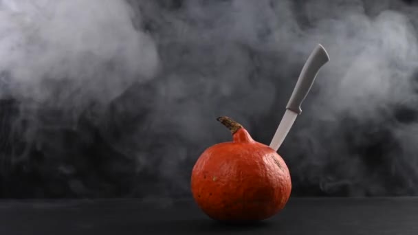 A knife in a pumpkin in the smoke. Happy Halloween. — Stock Video