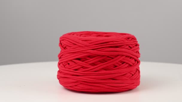 Boule rouge de fil de coton filant sur fond blanc. — Video
