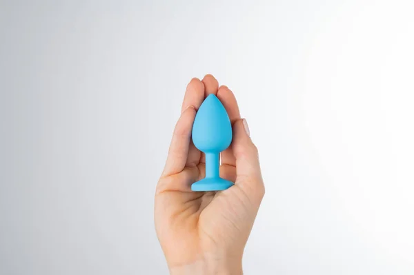 Woman holding a blue anal plug on a white background. Adult toy for alternative sex — Stock Photo, Image