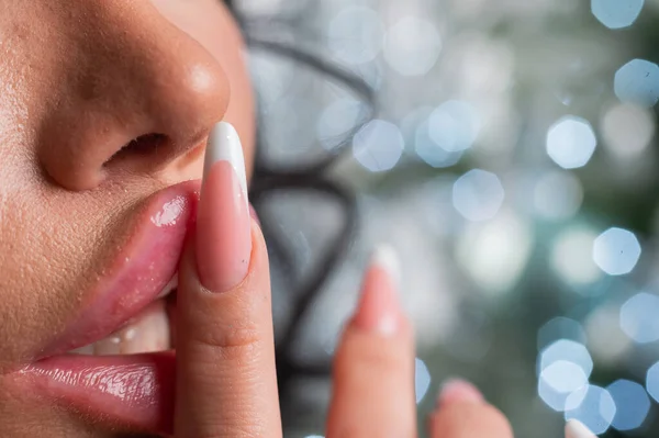Zbliżenie dużych pulchnych żeńskich ust na tle świątecznych dekoracji. — Zdjęcie stockowe