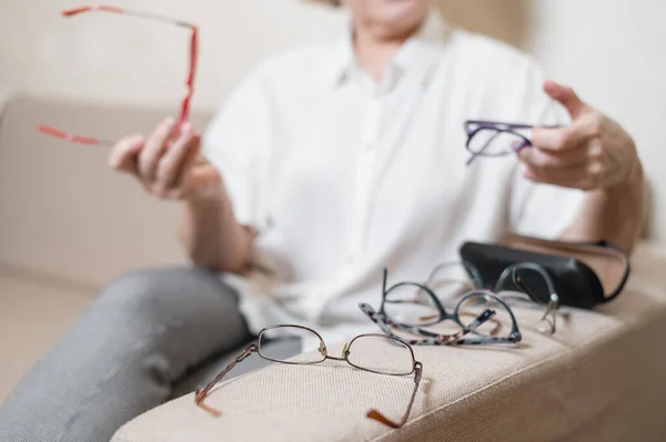 연로 한 코카서스 여자 가집에서 안경을 고르는 모습 — 스톡 사진