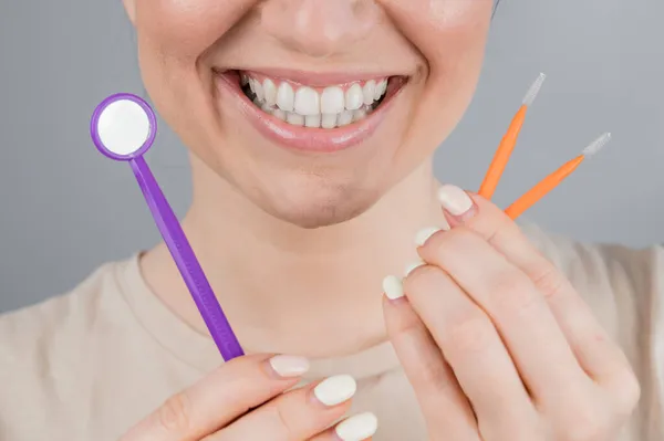 Retrato de close-up de uma mulher sorridente segurando uma escova e um espelho dental. Widescreen — Fotografia de Stock