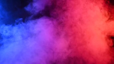 Siyah arkaplanda pembe-mavi dumanlar tütüyor,.