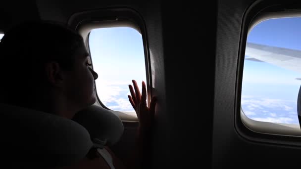Biała kobieta wyglądająca przez okno samolotu podczas lotu. Podróż w podróż. — Wideo stockowe
