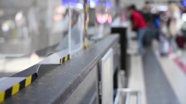 Kimliği belirsiz bir kadın havaalanı gişesinde pasaportunu veriyor..