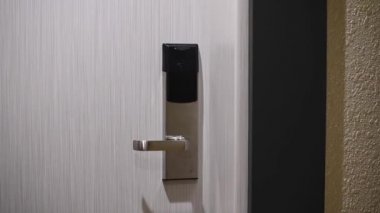 Bir kadın kartla elektronik kilidi açar ve bir otel odasına girer..