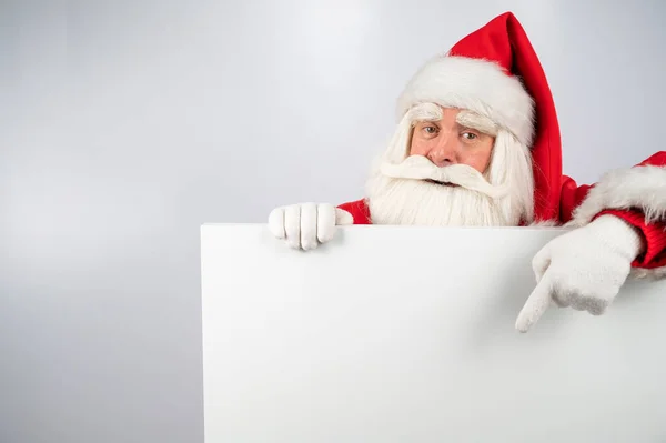 Ο Άγιος Βασίλης δείχνει ένα κενό λευκό χώρο. Διαφημιστική προσφορά για τα Χριστούγεννα. — Φωτογραφία Αρχείου