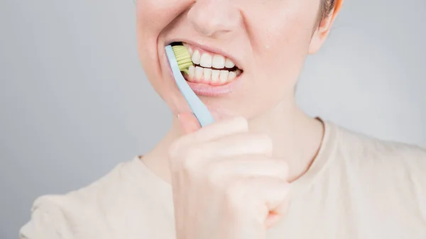 Close-up portret van een blanke vrouw die haar tanden poetst. Het meisje voert de ochtend mondhygiëne procedure — Stockfoto