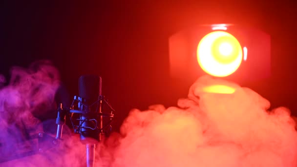 Profesjonalny mikrofon w różowym dymie na czarnym tle. — Wideo stockowe