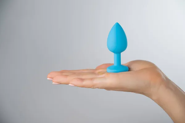 Frau mit blauem Analplug auf weißem Hintergrund. Erwachsenenspielzeug für alternativen Sex — Stockfoto