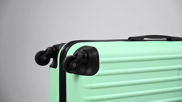 En kvinna träffar en resväska med en hammare på en vit bakgrund. — Stockvideo