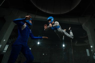 Bir erkek ve bir kadın rüzgar tünelinde birlikte uçmaktan zevk alırlar. Serbest düşüş simülatörü