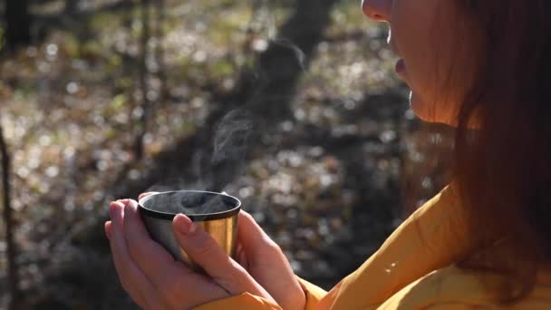 寒い秋の日に女性が魔法瓶から熱いお茶を飲む. — ストック動画