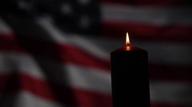 Amerika Birleşik Devletleri 'nin bayrağını sallayan arka planda yanan mum..