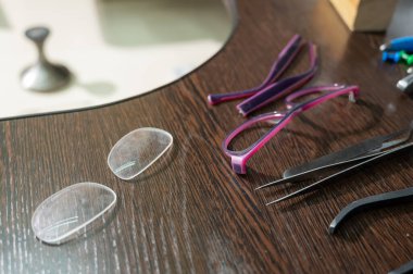 Optik teknisyen çalışma masası. Lens çerçeveleri ve tornavidaların yakın plan görüntüsü.