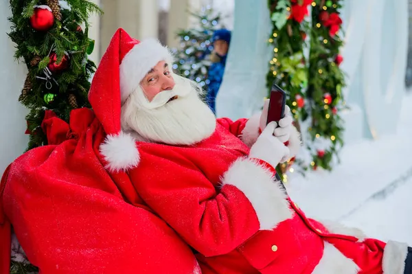 Santa Claus usando el teléfono al aire libre. Feliz Navidad.. — Foto de Stock