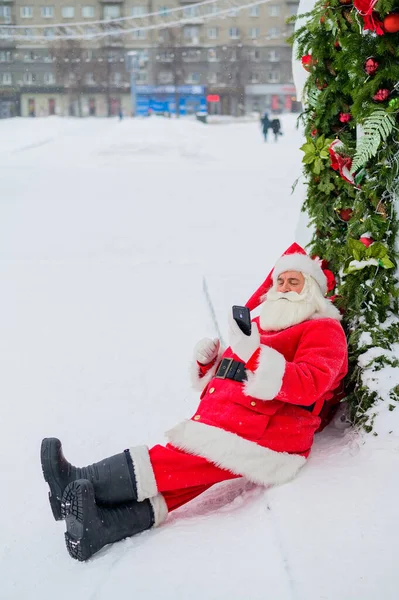 Santa Claus usando el teléfono al aire libre. Feliz Navidad.. —  Fotos de Stock