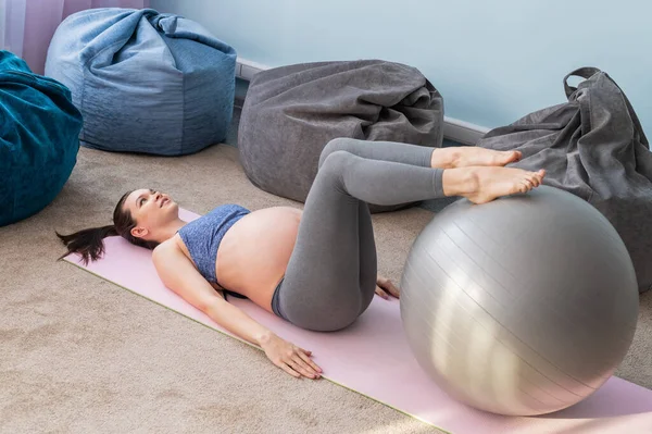 Těhotná běloška na fitness s míčem. Jóga pro nastávající matky. Dívka ve třídě se připravuje na porod. Pilates v posledním trimestru. — Stock fotografie