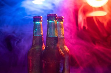 Mavi-pembe bir siste üç şişe bira..