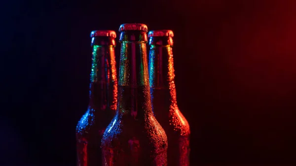 Tres botellas de cerveza en una niebla azul-rosa. — Foto de Stock