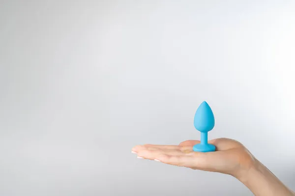 Woman holding a blue anal plug on a white background. Adult toy for alternative sex — Stock Photo, Image