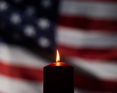 Amerika Birleşik Devletleri 'nin bayrağını sallayan arka planda yanan mum..