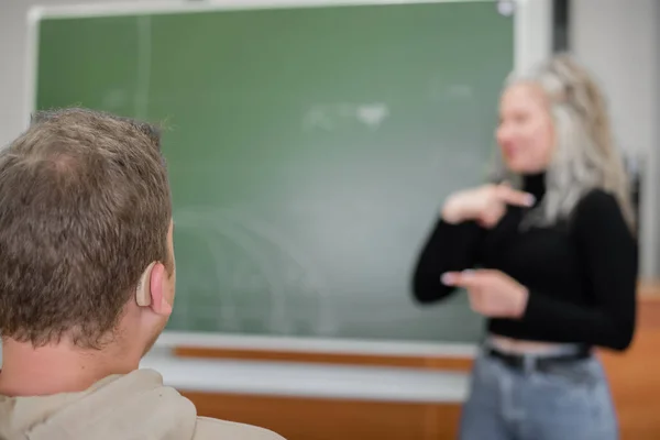 La fille et le gars parlent en langue des signes russe. Trois étudiants sourds bavardant dans une classe universitaire — Photo