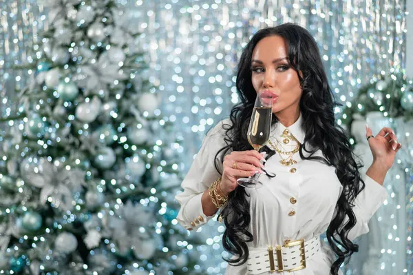Elinde bir bardak şampanya tutan seksi esmer. Kadın mutlu Noeller diliyor. — Stok fotoğraf