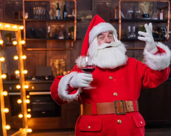Санта-Клаус с бокалом красного вина желает счастливого Рождества и говорит тост — стоковое фото