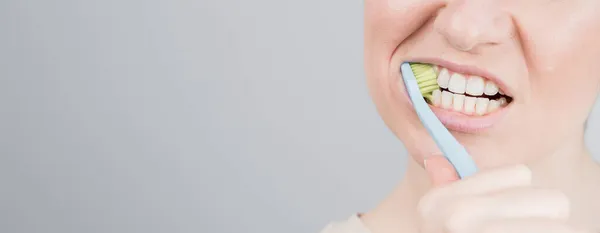 Foto close-up dari wanita kaukasia menggosok giginya. Gadis itu melakukan prosedur kebersihan mulut pagi — Stok Foto