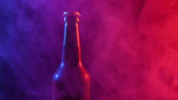 啤酒瓶在蓝色粉红烟雾中旋转. — 图库视频影像