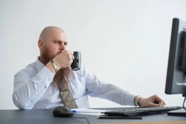 Problemas para el oficinista. Un hombre calvo con una camisa blanca se sienta en un escritorio con una computadora y está estresado por el fracaso. Una crisis nerviosa . —  Fotos de Stock