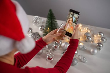 Kadınlar Noel 'i kutlamak için şampanya içer ve akıllı telefonla iletişim kurarlar.